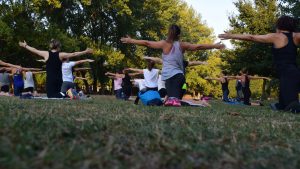 A group practices yoga outdoors.
