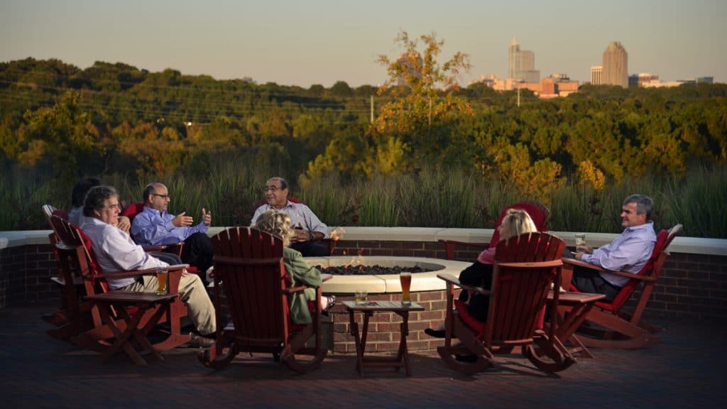 Friends enjoy drinks around the firepit at the Lonnie Poole Golf Course.