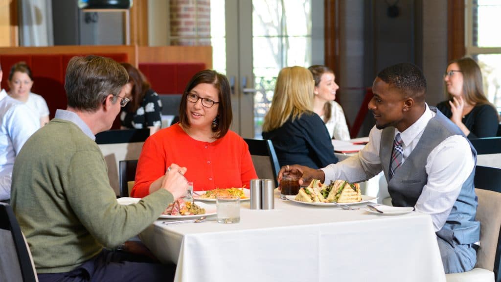 People enjoy a meal at the Park Alumni Center.