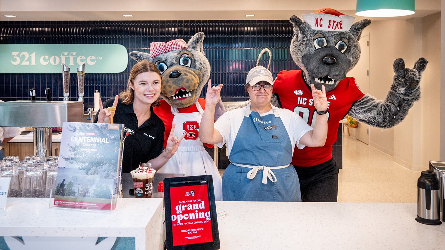 The Wufs mascots pose with employees of 321 Coffee inside the new location on Centennial Campus.